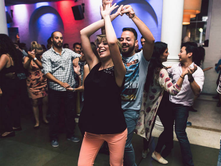 A crowd of people doing salsa dancing in a room at Establishment