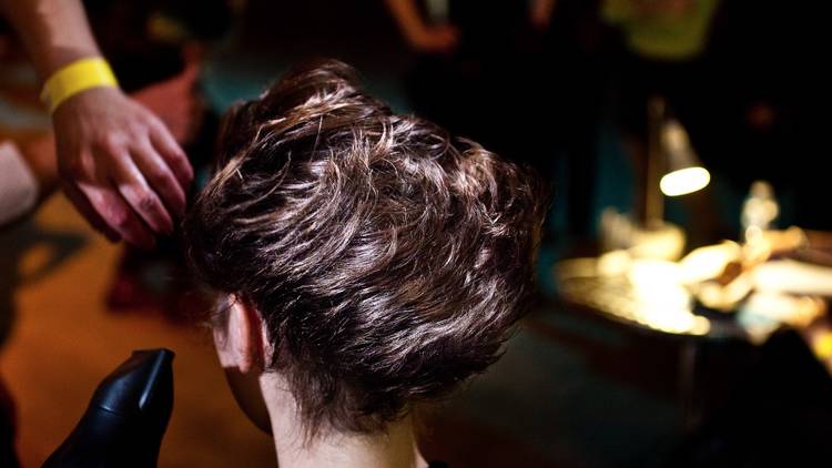 A shot of a person getting their hair blow dried at a salon.