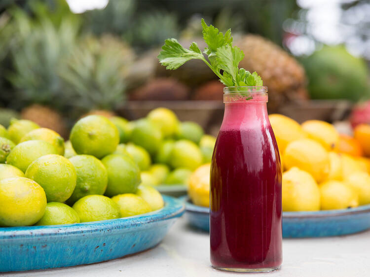 A beetroot juice surrounded by citrus fruits