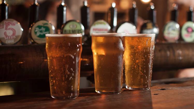 A shot of three glasses with beer and cider