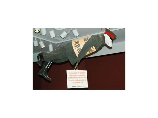 John Heartfield and Rudolf Schlichter, Prussian Archangel, 1920, reconstruced 2004. Reconstruction by Angelika Mende, Werkstatte für Unbeschaffbares, Berlin 2004. Papier-mâché (pig’s head); wire mesh (body); palm grass, hemp, and horse hair (filling); uniform cut from field gray material, following original pattern; World War I field cap, boots and shoulder lapels; woodcut signs.