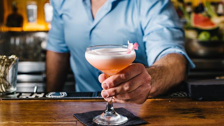 A bartender with a cocktail at Barrio Cellar in Sydney