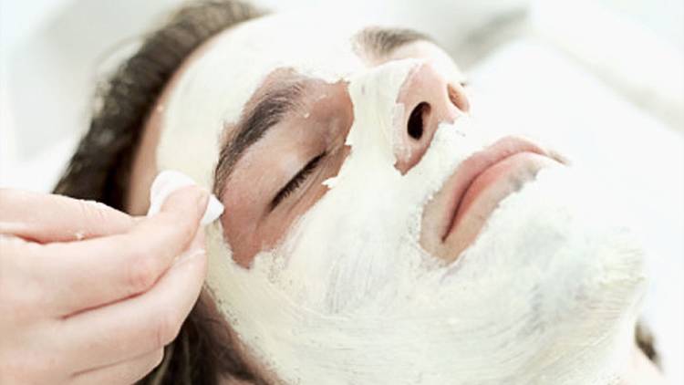 A man receives a facial treatment at a spa