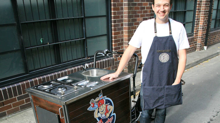 busboy owner standing in front of food cart