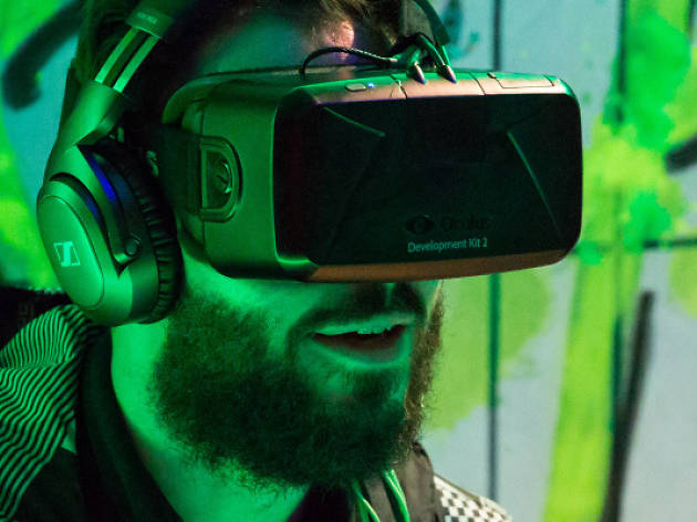 Virtual Reality at the Hub Amidst green lighting a man wears a virtual reality headset to watch a film
