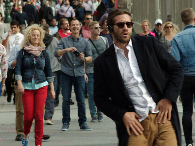 Demolition Jake Gyllenhaal walking down the street with headphones