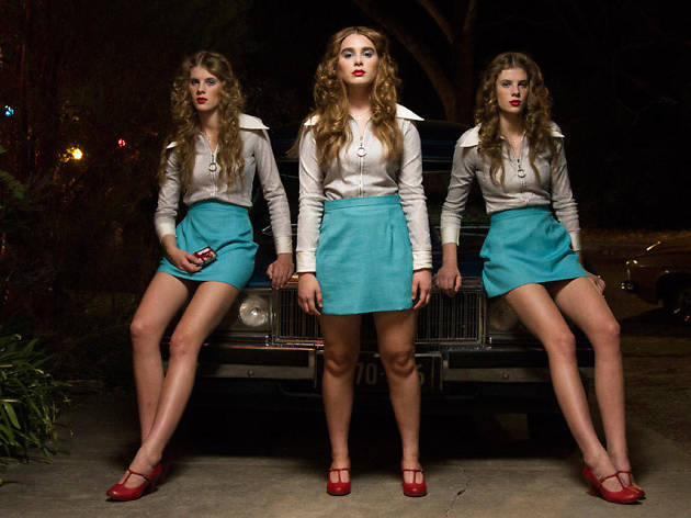 Girl Asleep Three Girls in 1970s fashion stand in front of a car