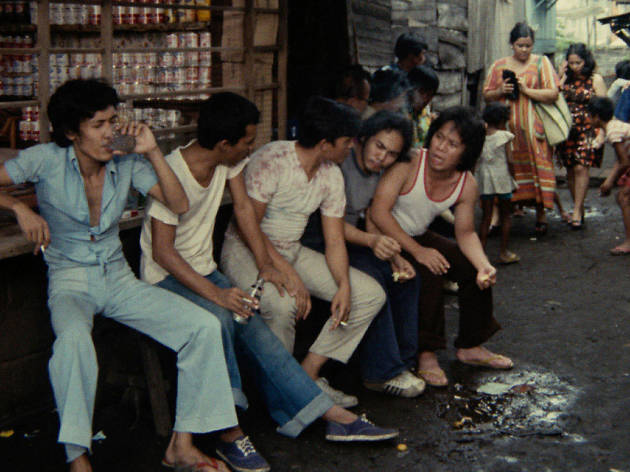 Insiang five Filipino men sit on the street talking in Insiang