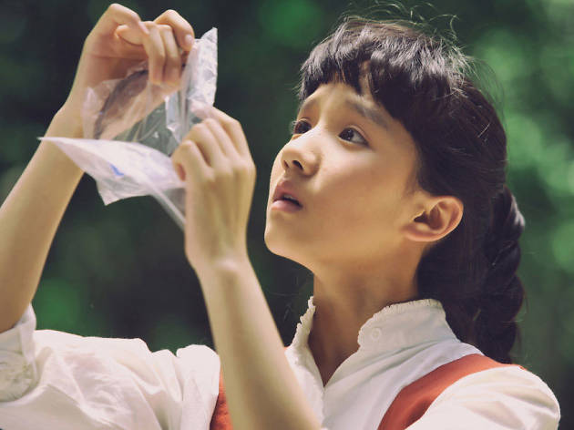 What's in the Darkness A young Chinese girl inspects evidence in a plastic bag
