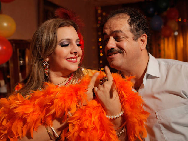 Halal Love (And Sex) A woman with an orange feather boa and man in a room with balloons