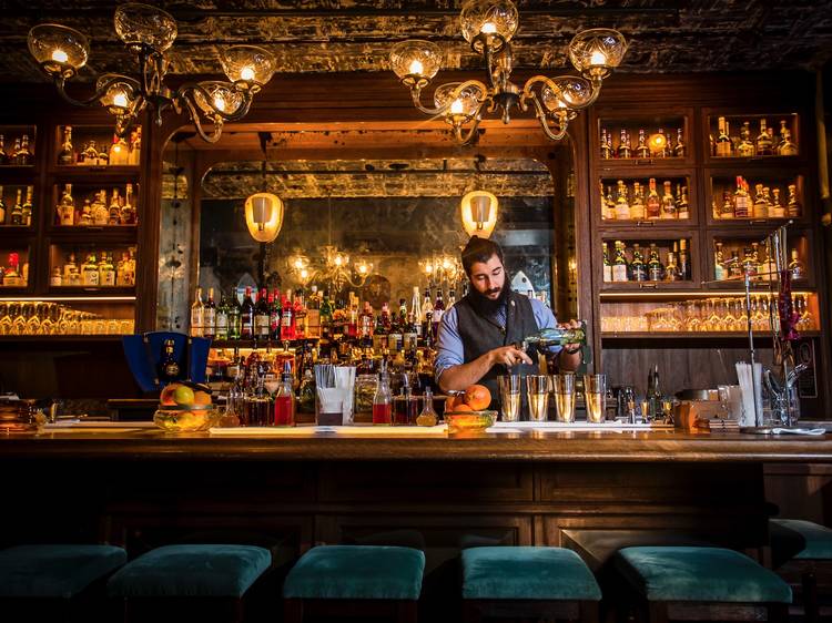 Bartender preparing four cocktails