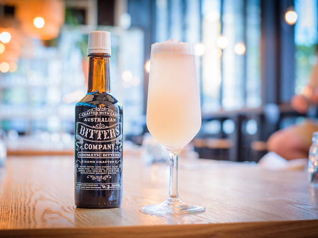 Hunter Gatherer CCA Dry July mocktails A mocktail on a wooden table with a bottle of bitters