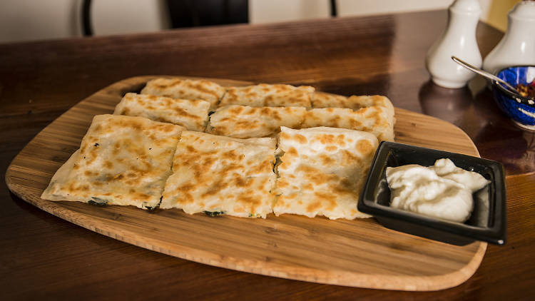 A Turkish pastry on a plate on a timber table