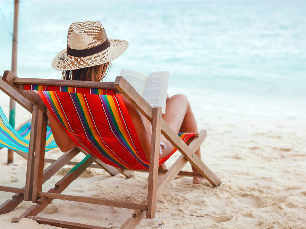 Dona llegint a la platja Dona llegint a la platja