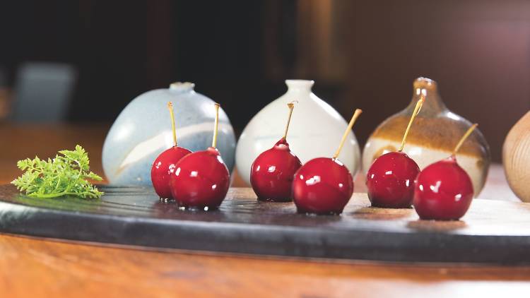 Cherry foie gras on a plate in front of sauce pots