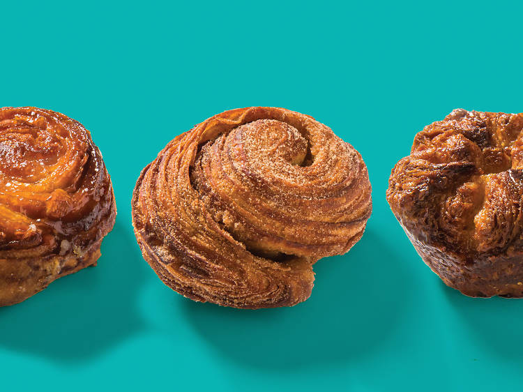 Three kouign amanns on a turquoise background