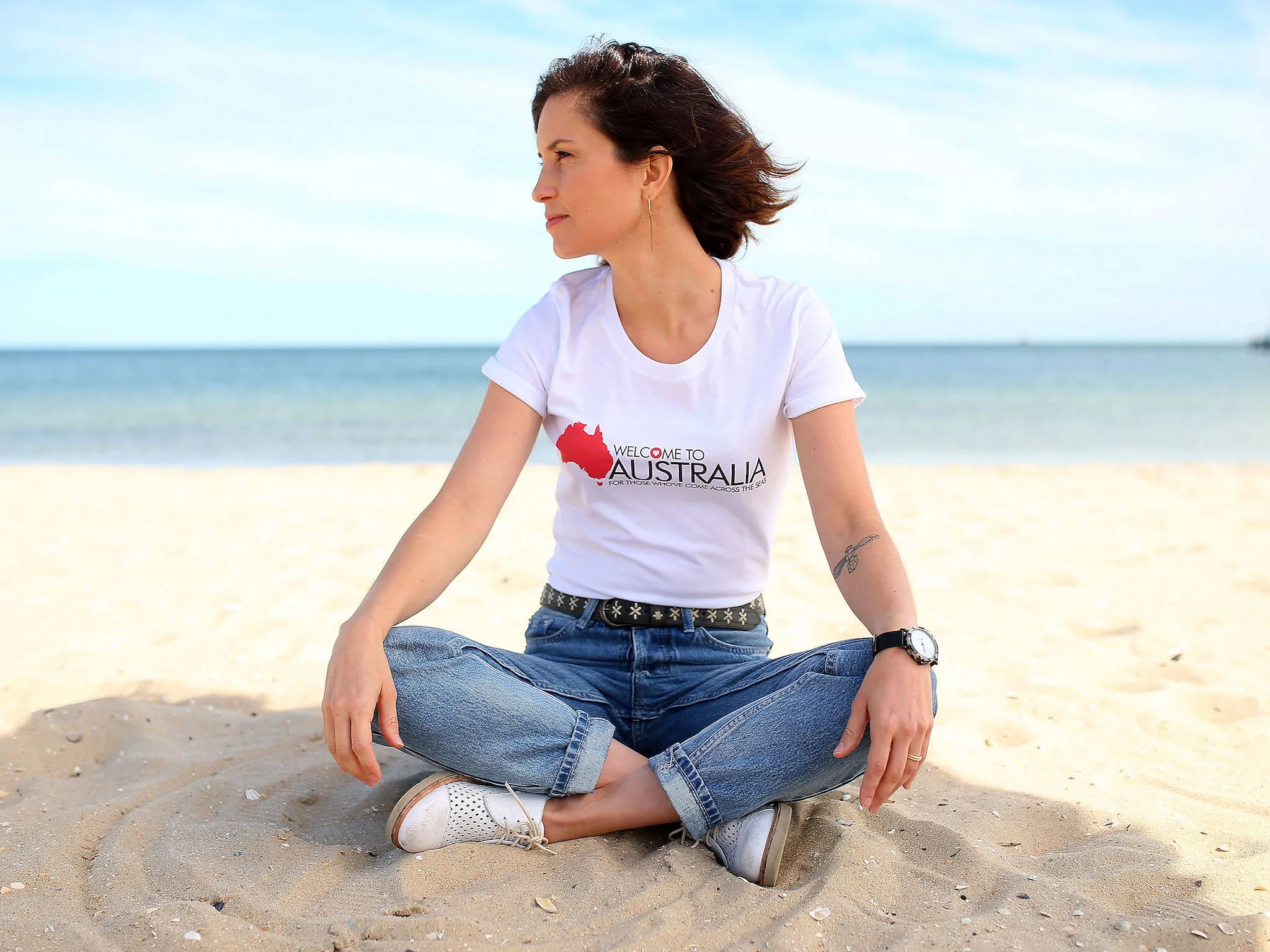 Missy Higgins sitting cross-legged on the beach
