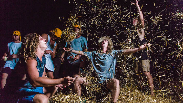 Young men throwing hay and dancing at Mountain Sounds