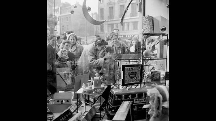 Children peer into Hamleys toy store window, 1957