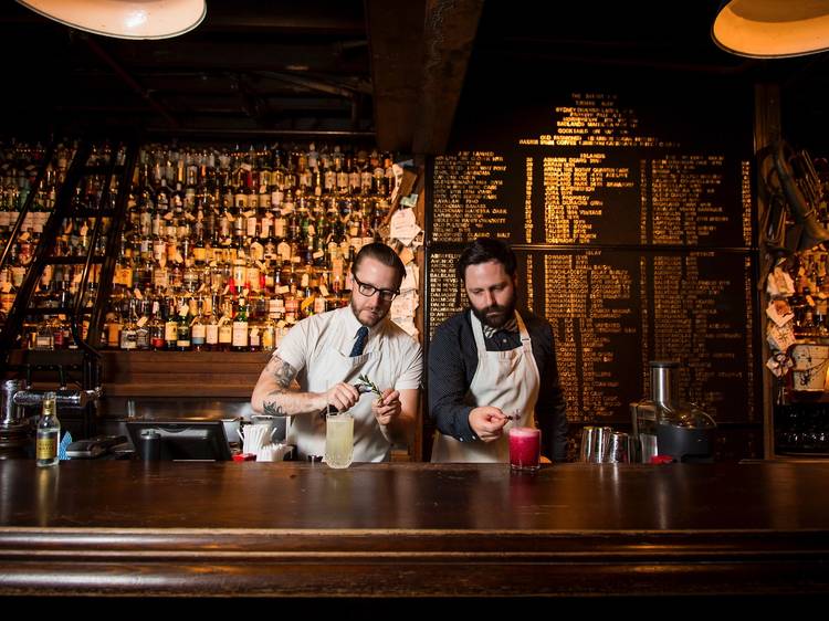 Two bartenders pouring whisky