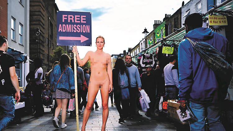 Photo of Ursula Martinez standing naked in a marketplace