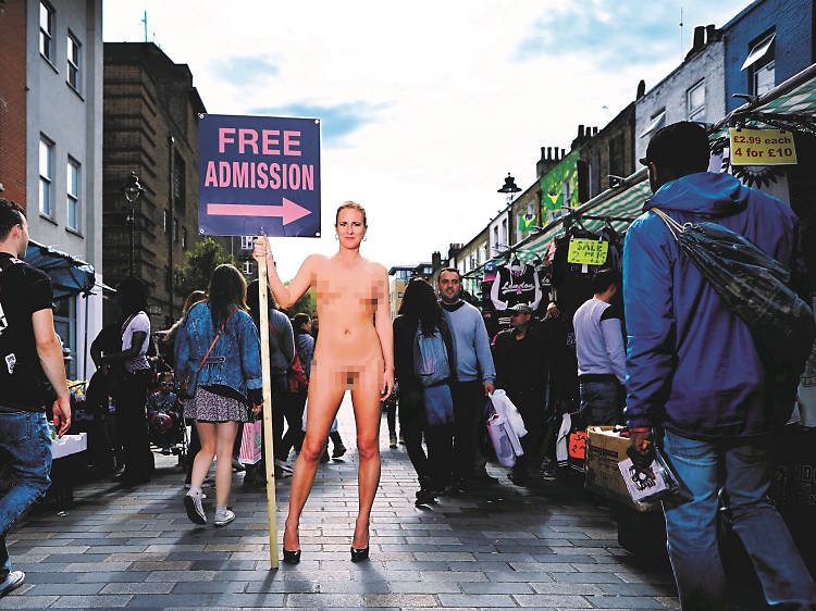 Photo of Ursula Martinez standing naked in a marketplace