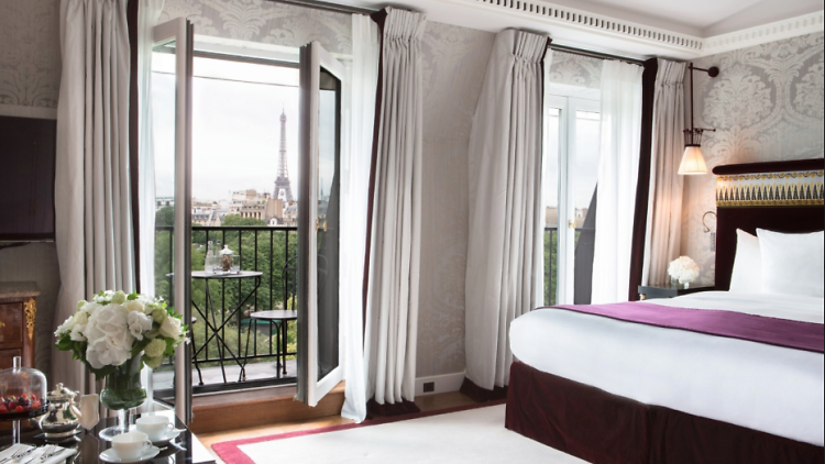 A hotel bedroom in Paris with views of the Eiffel Tower.