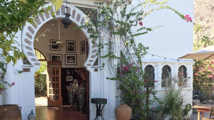 Korakia Pensione front entrance, with potted plants and a large doorway