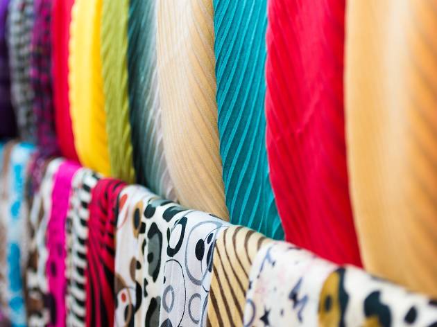 Row of new multicolored scarves at shop.