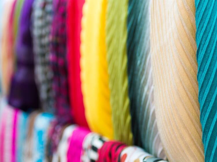 Row of new multicolored scarves at shop.