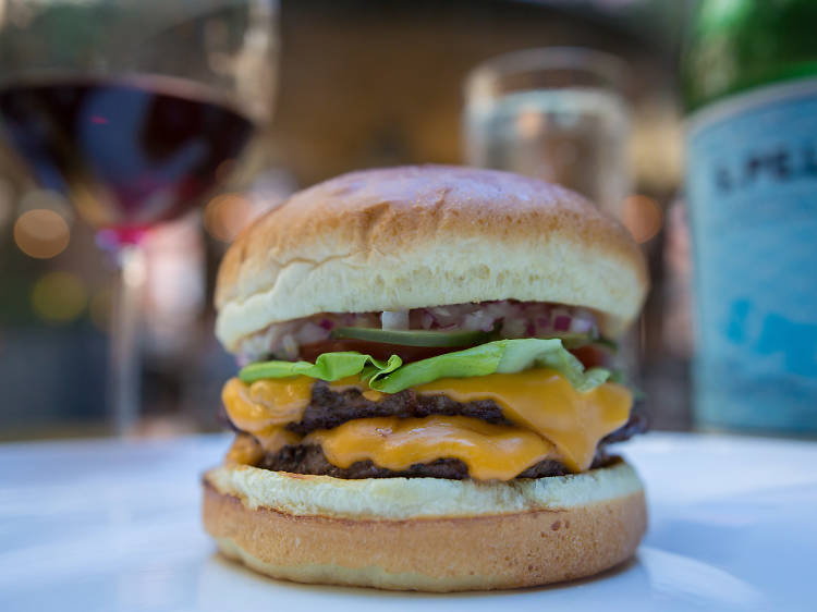 Blue Roof Bistro - Roasted Chili Steak Burger has a roasted chili sauce,flank  steak, beef patty, arugula, and melted Swiss in a potato bun served w/ a  side is the special of