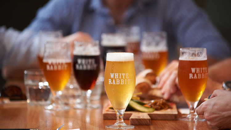 Glasses of beer with 'white rabbit' written on it, at a venue with cheese