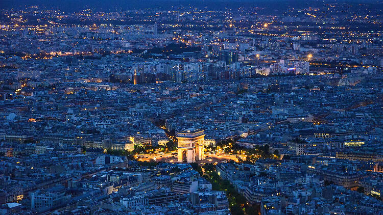 A view of the city at night, including the Arc de Triomphe