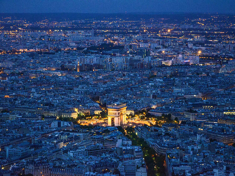 A view of the city at night, including the Arc de Triomphe