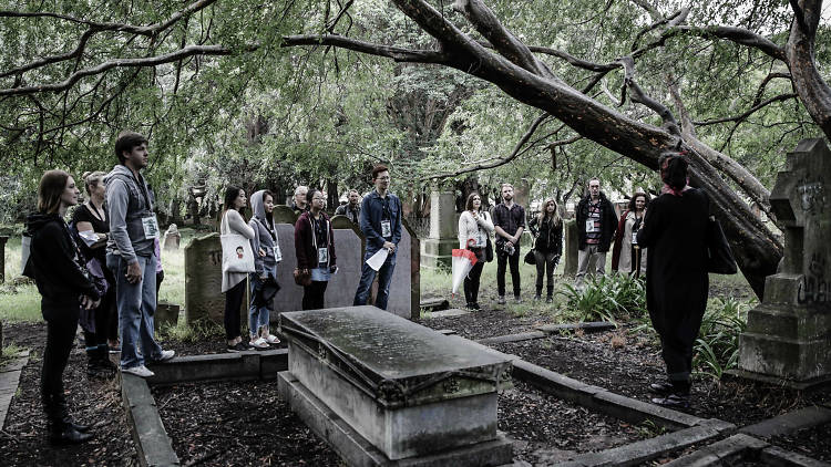 Group of people standing around a graveyard