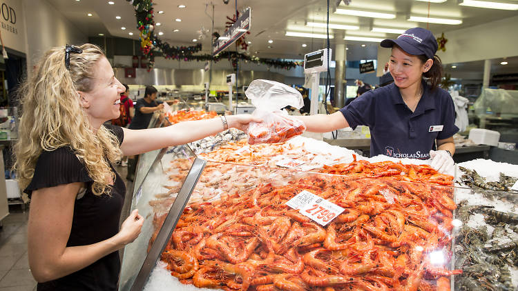 Woman buying prawns at the fish market