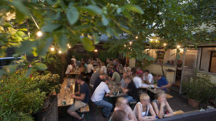 Diners eating in the garden area of Klaane Sachsehauser restaurant in Frankfurt