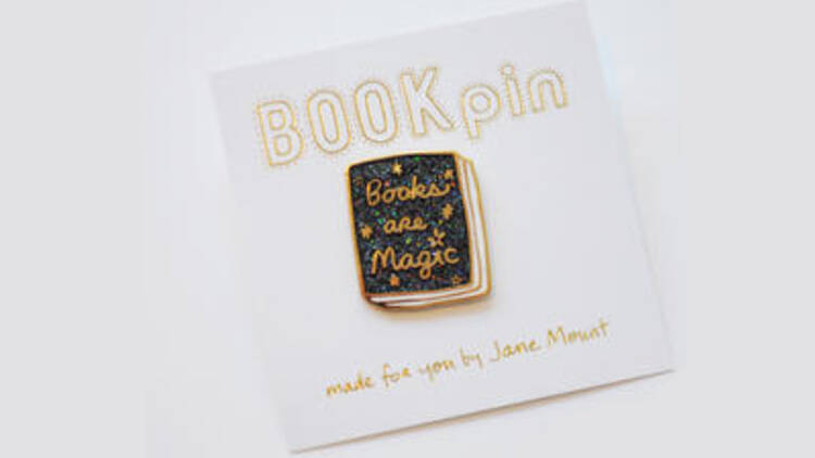 A tote bag and pin from Books Are Magic