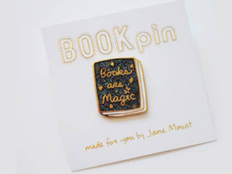 A tote bag and pin from Books Are Magic