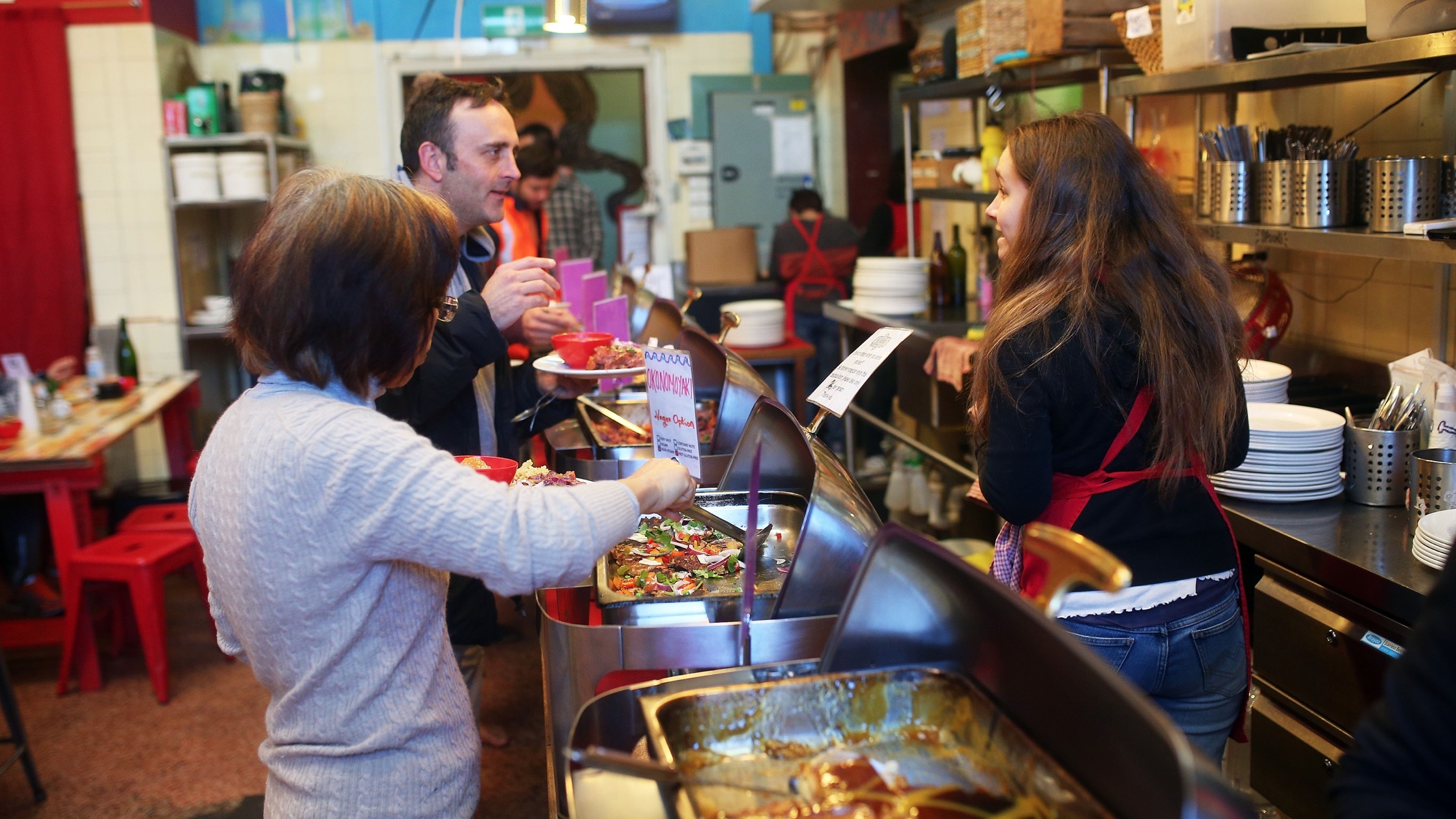 Person serving food at Lentil As Anything