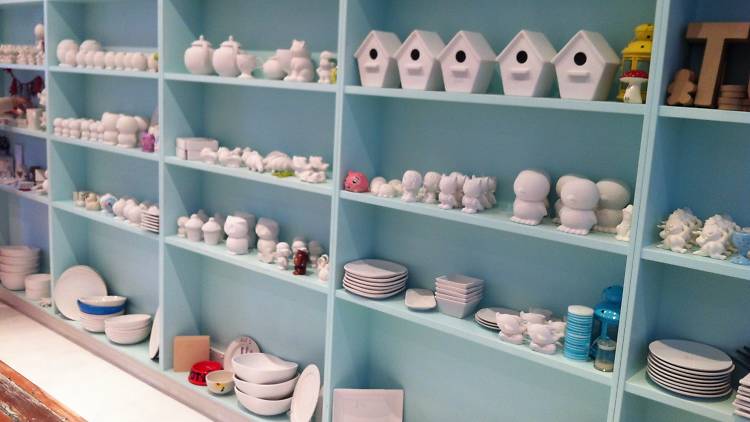 A range of ceramics on a blue shelf ready to be painted.