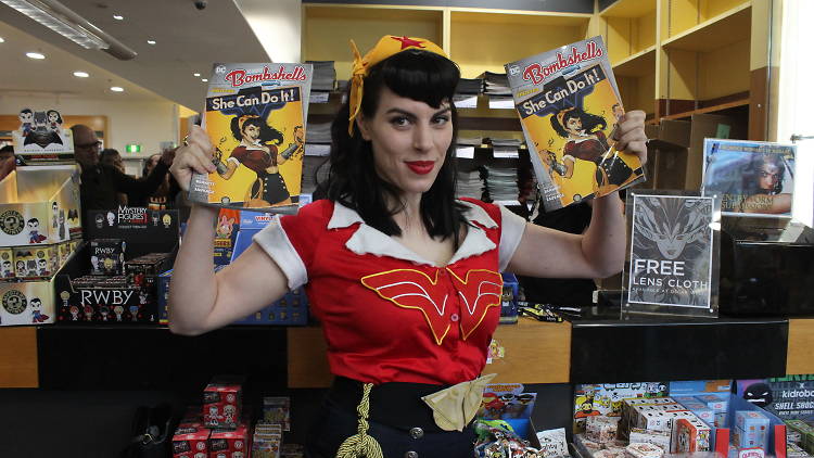 Cosplayer poses with comic books.