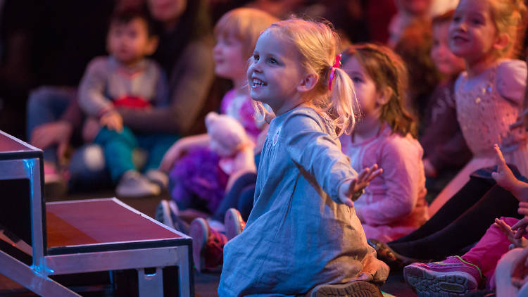 Kids watch a stage performance.