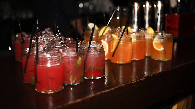 Cocktails lined up in jam jars.