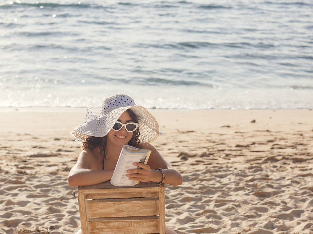 Dona llegint a la platja Dona llegint a la platja