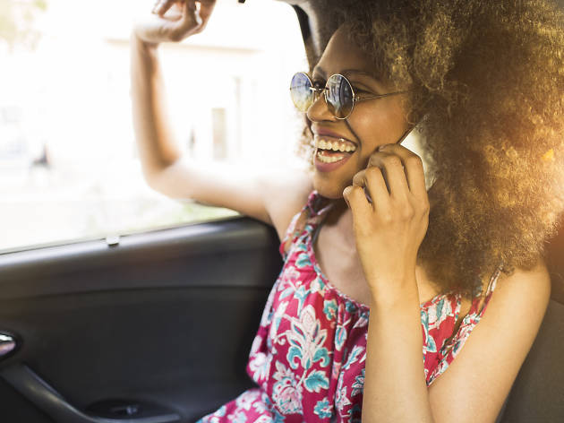 Young beautiful woman in taxi and using a phone 516595768