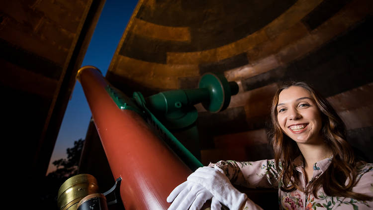 Kirsten Banks standing with a telescope at Sydney Observatory