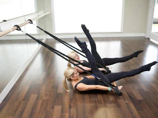 Xtend Barre Alexandria Three women doing barre exercises in a studio