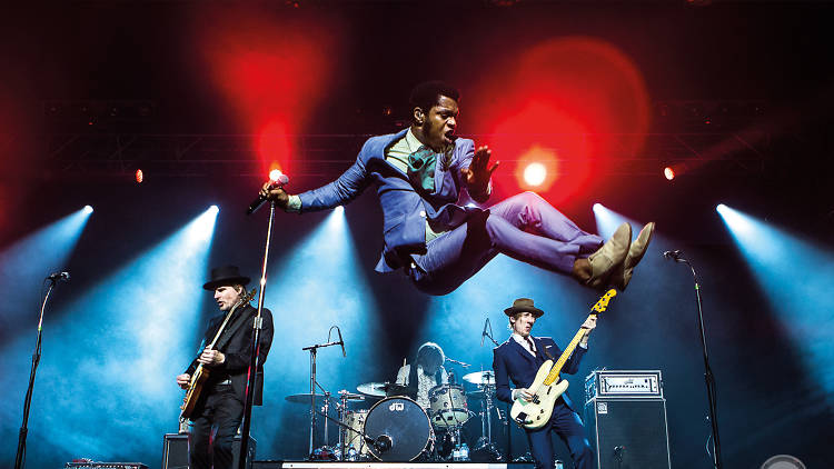 Band jumps around on stage with instruments