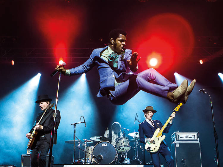 Band jumps around on stage with instruments